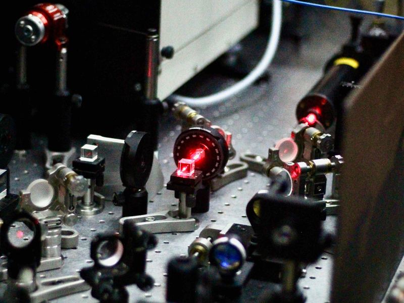 Optics on the lab table with red laser light